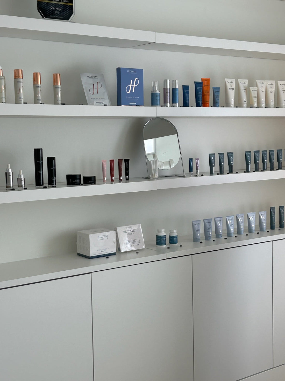Skincare products for different skin types arranged on clean white shelves